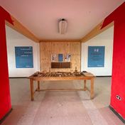 Sala de taller recuperada en la Escuela Valle Simpson, con mesa de herramientas y muros rojos